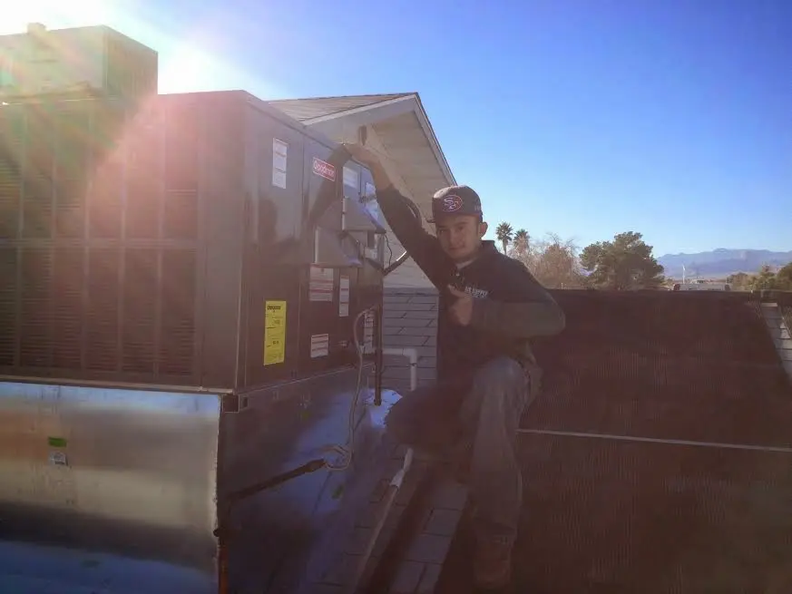 HVAC technician performing Air Duct Repair on a rooftop unit in Granville